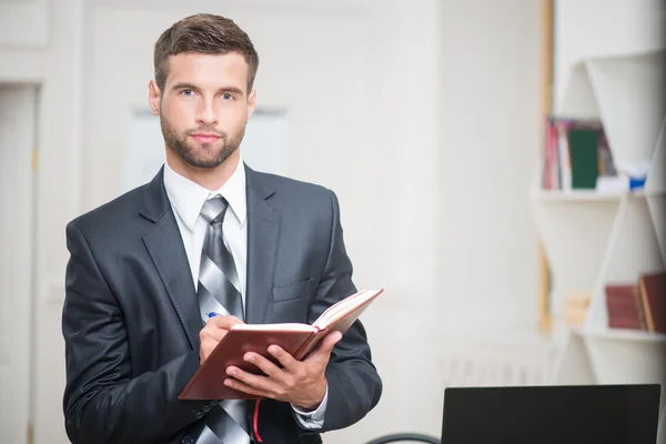 Empresario escribiendo algunas notas en cuaderno — Foto de Stock