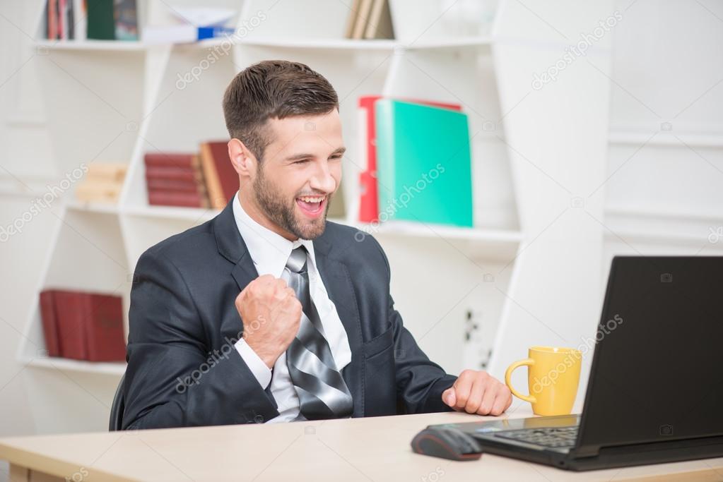 Happy businessman looking at laptop