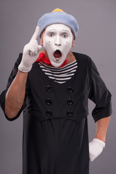 Male mime showing sign Attention with opened mouth