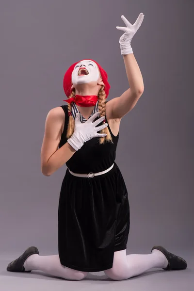 Portrait of female mime with red hat and white face grimacing wi — Stock Photo, Image