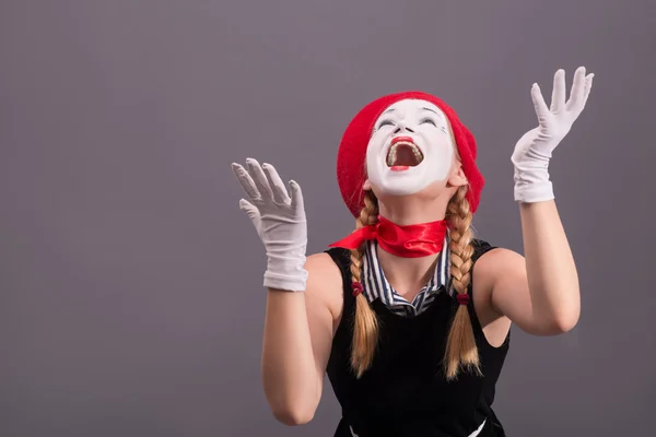 Porträtt av kvinnliga mime med röd hatt och vitt ansikte grimaserande wi — Stockfoto