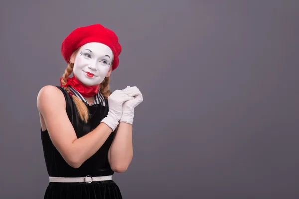 Porträtt av kvinnliga mime med röd hatt och vitt ansikte grimaserande wi — Stockfoto