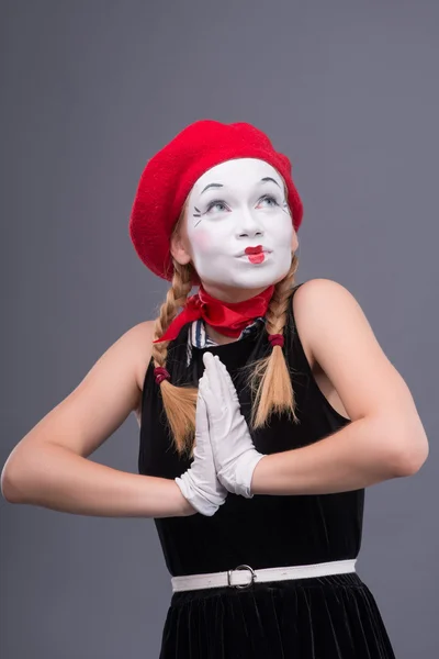 Porträtt av kvinnliga mime med röd hatt och vitt ansikte grimaserande wi — Stockfoto