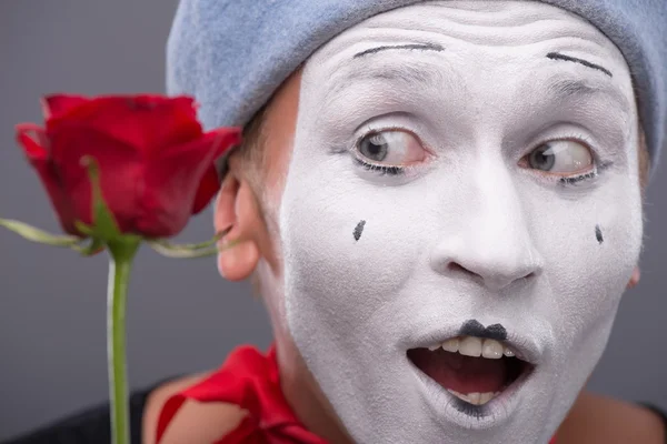 Waist-up portrait of young male mime holding a flower isolated o — Stock Photo, Image