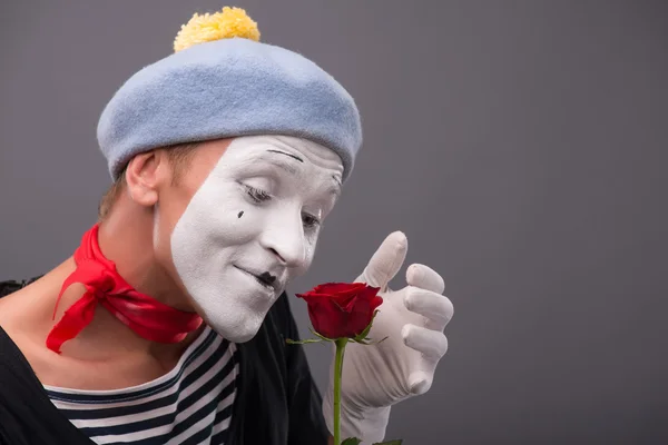 Waist-up portrait of young male mime holding a flower isolated o — Stock Photo, Image
