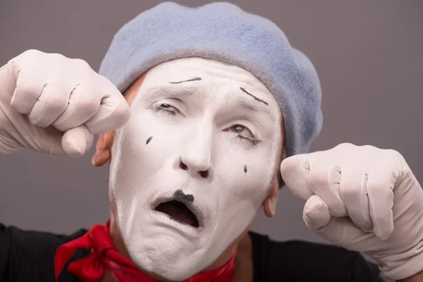 Portrait of young male mime with white face, grey hat showing em — Stock Photo, Image