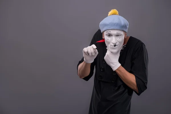 Portrait of young male mime with white face, grey hat showing em — Stock Photo, Image