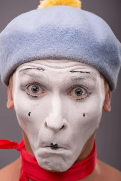 Portrait of young male mime with white face, grey hat showing em — Stock Photo, Image