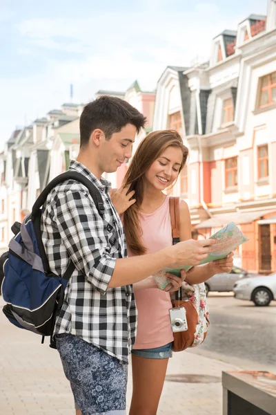 Couple of tourists holding a map — Stock Photo, Image