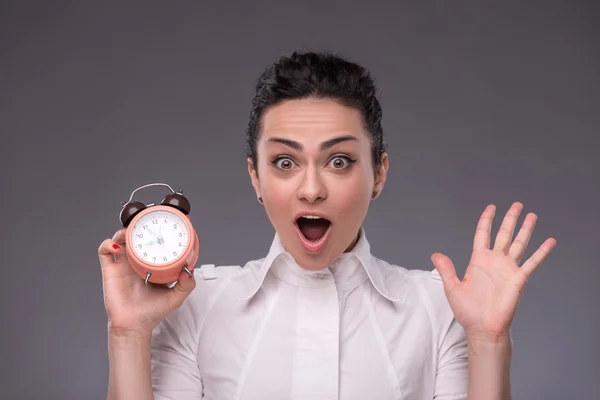 Retrato de una chica bonita sosteniendo un despertador — Foto de Stock