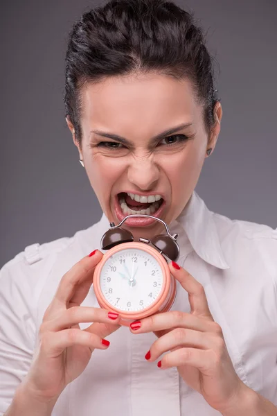 Close-up portrait of beautiful girl holding an alarm clock in he — Stock Photo, Image