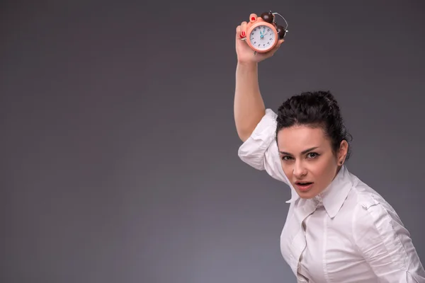 Portrait of pretty girl holding an alarm clock in her hand showi — Stock Photo, Image