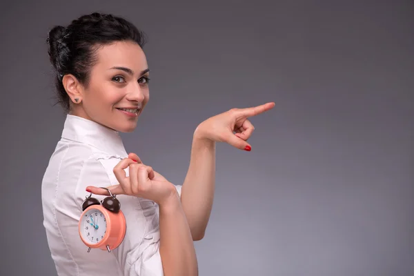 Portret van mooi meisje houdt van een wekker in haar hand kleurend — Stockfoto