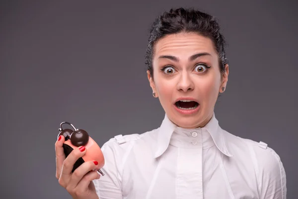 Mädchen mit überraschtem Gesicht, das einen Wecker hält — Stockfoto