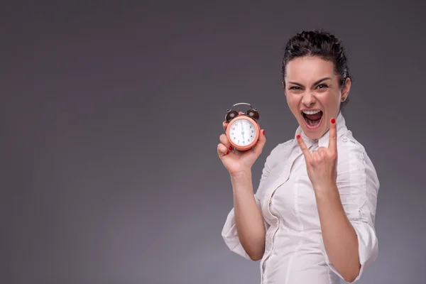 Chica sosteniendo un reloj despertador, mostrando señal Rock —  Fotos de Stock