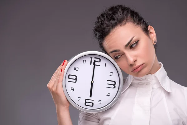 Retrato de una buena chica sosteniendo un gran reloj en sus manos aisladas en — Foto de Stock