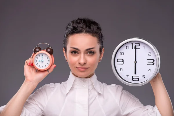 Portrait of nice girl holding big clock in her hands isolated on — Stock Photo, Image