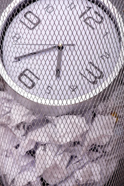 Photo rapprochée d'une horloge dans une poubelle avec d'autres rubbis de bureau — Photo