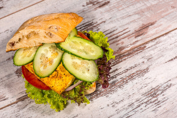 Крупный план вегетарианского сэндвича с тофу, помидорами, салом
