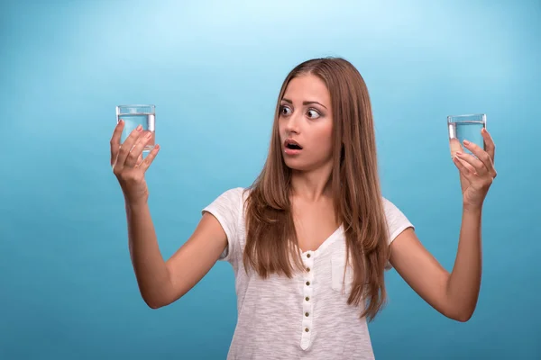 Meisje met verbaasd gezicht bedrijf twee glazen met schoon water — Stockfoto