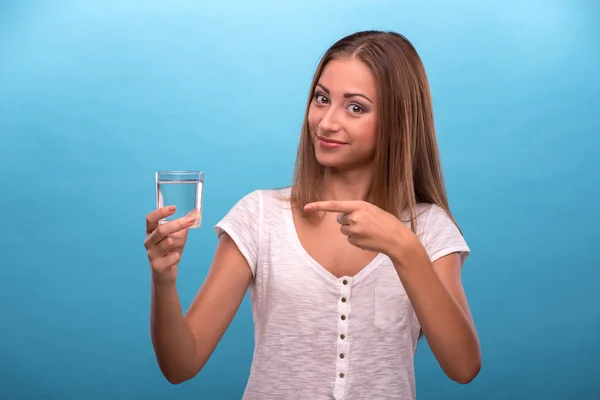 Muchacha mostrando con el dedo en un vaso con agua — Foto de Stock