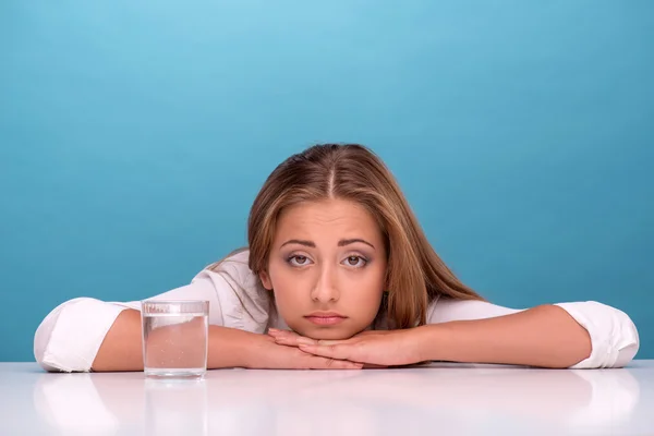 Ragazza seduta vicino a un bicchiere con acqua pulita — Foto Stock