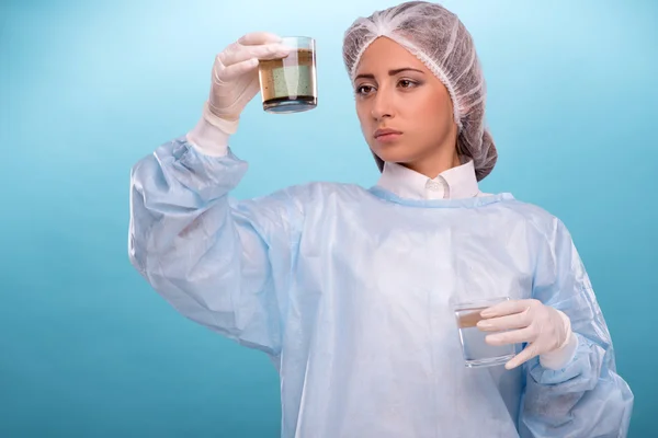 Portrait of young woman wearing overall while testing the qualit — Stock Photo, Image