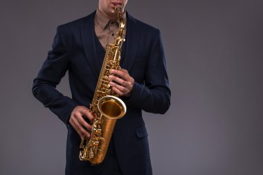Yakın çekim bir jazz'ın elinde bir trompet resmini ben takım elbiseli adam