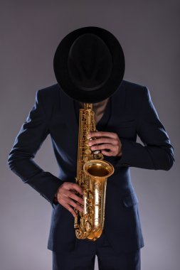 Portrait of a jazz man in a suit with a hat hiding his face and clipart
