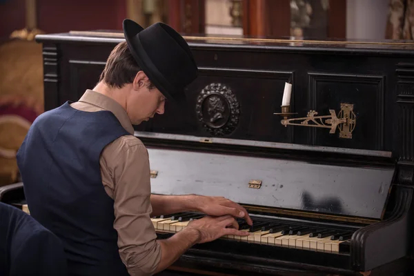 Portrait of a musician in suit and in black hat playing the pian — Stock Photo, Image