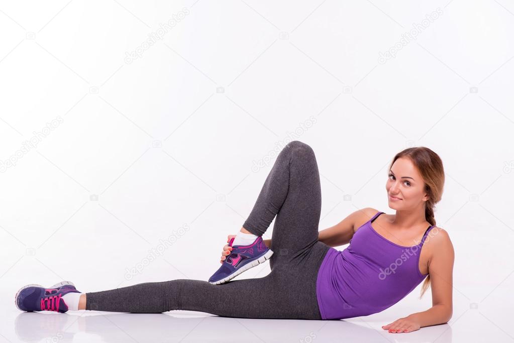 Healthy young sportswoman does the exercises
