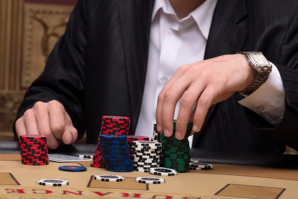 Chips i högar nära spelare i casino — Stockfoto