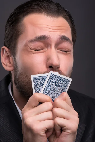 Man   kissing   cards  for luck — Stock Photo, Image