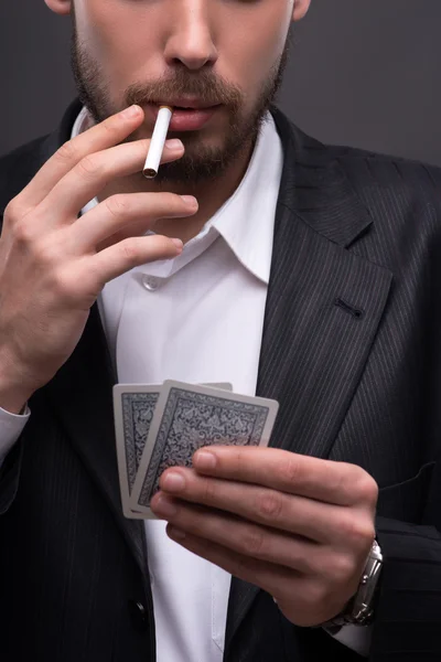 Man  smoking  holding cards — Stock Photo, Image