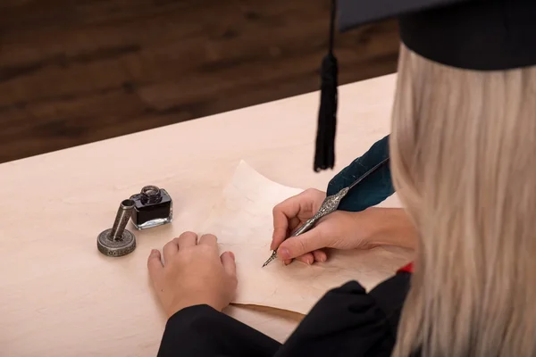 Студентська дівчина пише з чорнилом і пером — стокове фото