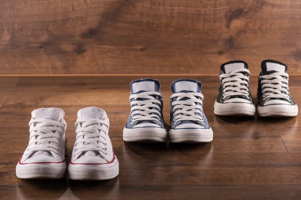 Multicolored youth gym shoes on floor — Stock Photo, Image