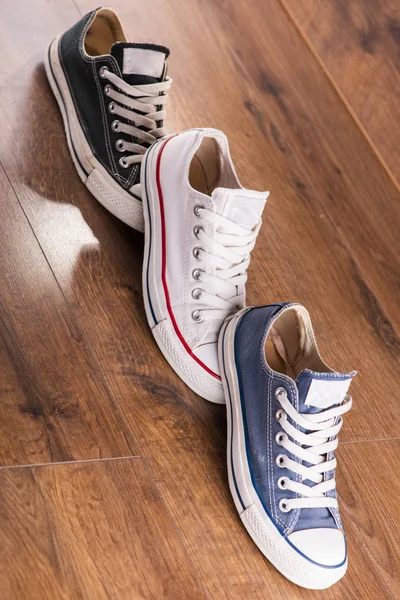 Multicolored youth gym shoes on floor — Stock Photo, Image