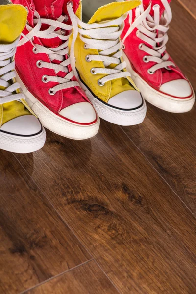 Різнокольорове молодіжне спортивне взуття на підлозі — стокове фото