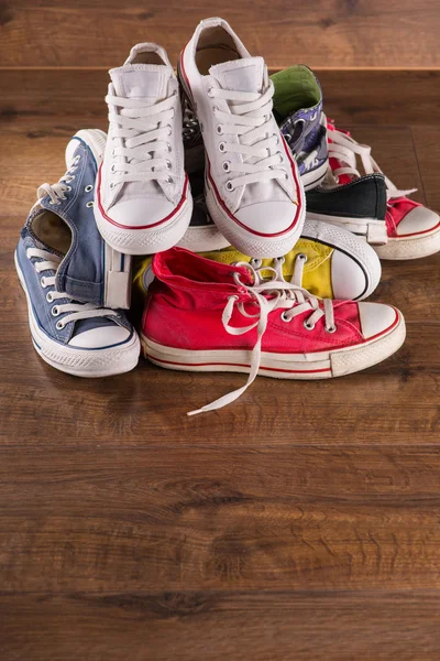 Різнокольорове молодіжне спортивне взуття на підлозі — стокове фото
