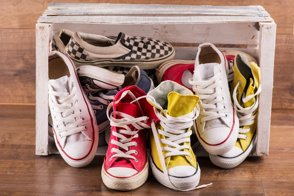 Multicolored youth gym shoes on floor — Stock Photo, Image