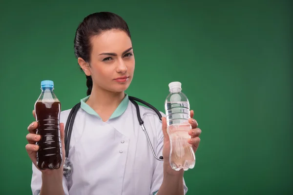 Vrouw arts met een fles mineraalwater — Stockfoto