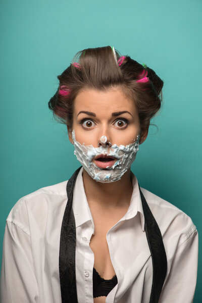 Женщина в бигуди с пеной на лице
