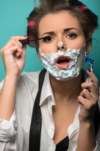 Brunette with razor applying mascara — Stock Photo, Image