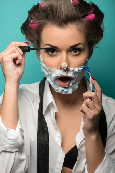 Brunette  with razor  applying mascara — Stock Photo, Image