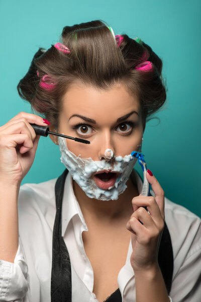 Женщина в пене на лице наносит тушь
