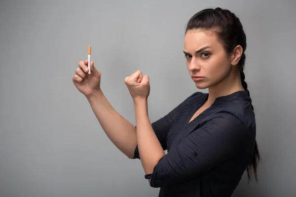 Chica sosteniendo cigarrillo mostrando puño . — Foto de Stock