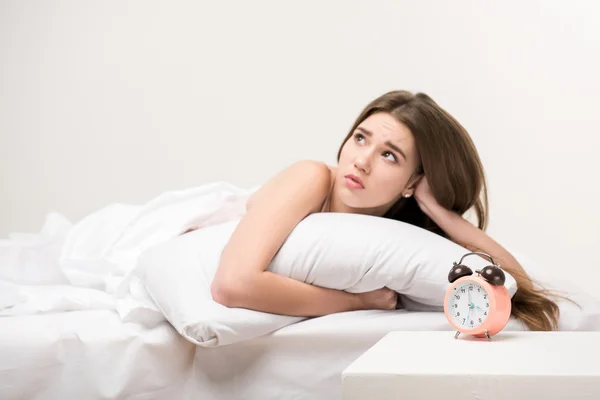 Frumusețe întinsă pe pat cu un ceas — Fotografie, imagine de stoc