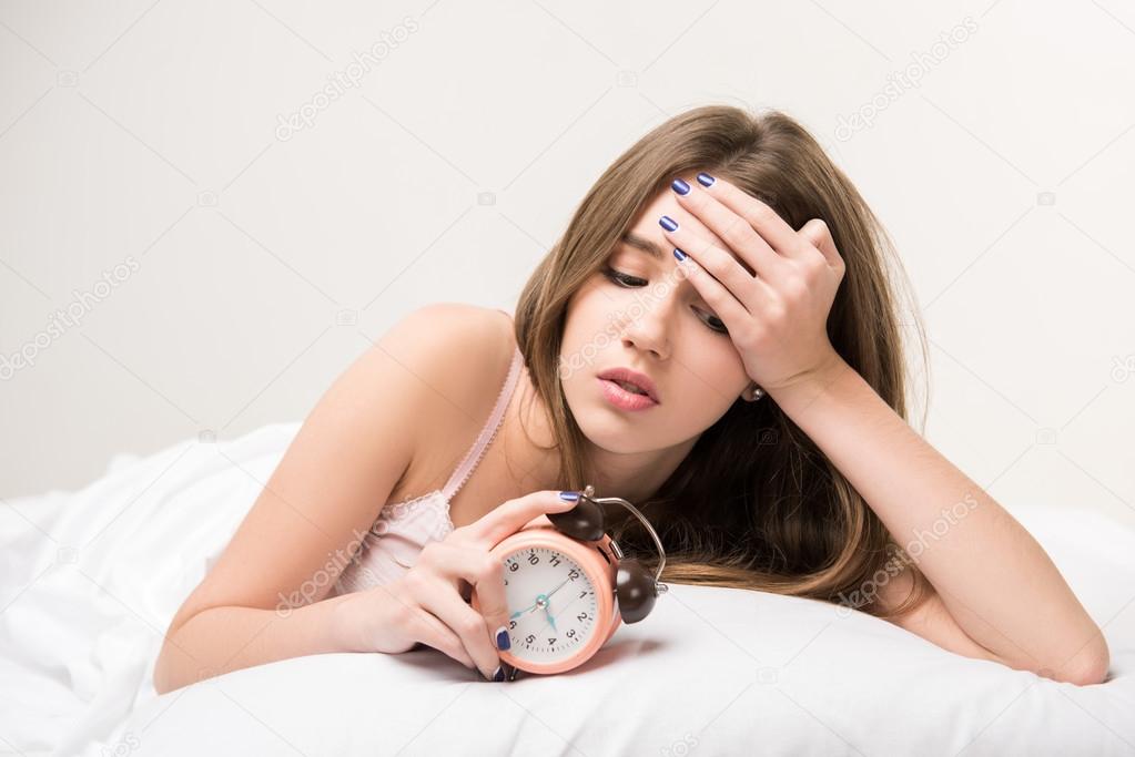 beauty lying on the bed with clock