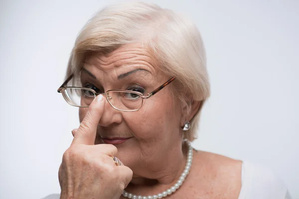 Curieux mamie regardant à travers ses lunettes — Photo