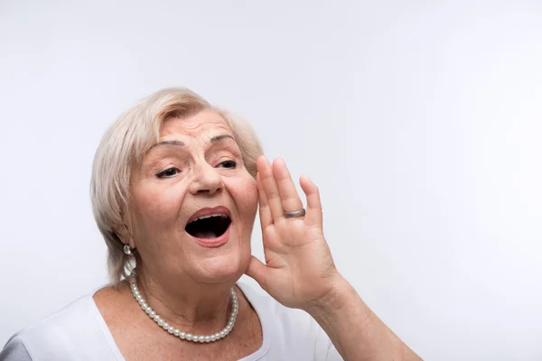 Elderly lady shouting putting hands by her mouth — Stock Photo, Image